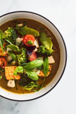Kızarmış ipek tofu brokoliyle vegan Thai yeşil körisi ve bahçeden taze toplanmış bezelyeler, sağlıklı bitki temelli yemek tarifleri.