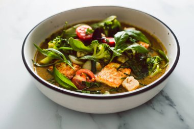 Kızarmış ipek tofu brokoliyle vegan Thai yeşil körisi ve bahçeden taze toplanmış bezelyeler, sağlıklı bitki temelli yemek tarifleri.