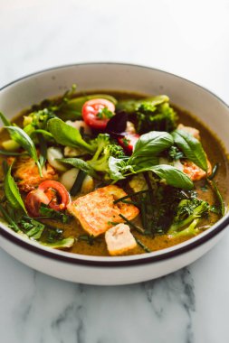 Kızarmış ipek tofu brokoliyle vegan Thai yeşil körisi ve bahçeden taze toplanmış bezelyeler, sağlıklı bitki temelli yemek tarifleri.