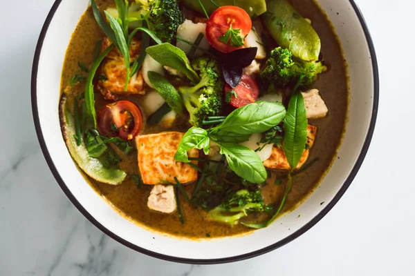 Kızarmış ipek tofu brokoliyle vegan Thai yeşil körisi ve bahçeden taze toplanmış bezelyeler, sağlıklı bitki temelli yemek tarifleri.