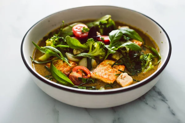 Kızarmış ipek tofu brokoliyle vegan Thai yeşil körisi ve bahçeden taze toplanmış bezelyeler, sağlıklı bitki temelli yemek tarifleri.