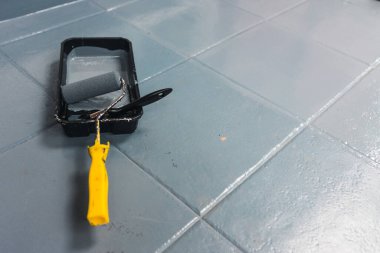 Çizik döşeme fayansları fırçalı yeni bir kat boya tepsisi, boya konsepti ve ev yenilemesi.