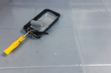 Çizik döşeme fayansları fırçalı yeni bir kat boya tepsisi, boya konsepti ve ev yenilemesi.