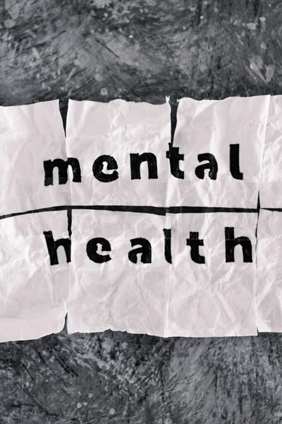 Mental health text on crumpled and torn piece of paper which has been reassembled with sticky tape, concept of psychology and emotional healing