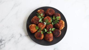 Vejetaryen pesto arancini kızarmış risotto topları üzerine taze maydanoz, sağlıklı bitki temelli yemek tarifleri.