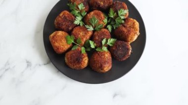 Vejetaryen pesto arancini kızarmış risotto topları üzerine taze maydanoz, sağlıklı bitki temelli yemek tarifleri.