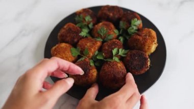 Vejetaryen pesto arancini kızarmış risotto topları üzerine taze maydanoz, sağlıklı bitki temelli yemek tarifleri.