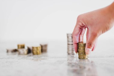 Altın ve gümüşleri de içeren minimalist kompozisyonu olan sığ alan derinliğine beyaz arka plan çekimleri için farklı madeni para yığınları yerleştirmek