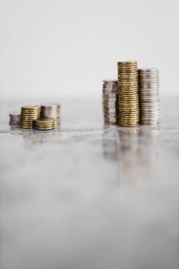 Beyaz arka planda küçük ve büyük bir gruba bölünmüş farklı madeni para yığınları, iyi ve kötü yatırımlar kavramı veya yatırım öncesi ve sonrası