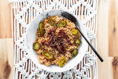 Kurutulmuş domatesli vejetaryen zencefilli şehriye ve kişniş tohumu ve otlarla kaplanmış jalapenolarla sağlıklı bitki temelli yemek tarifleri.