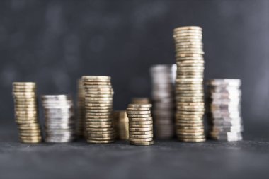 Farklı altın ve gümüş para yığınları büyük miktarda tasarruf, bolluk ve zenginlik kavramı yaratır.