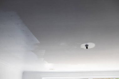 Taze boya tabakası tavanda yuvarlanıyor. Tebeşirle boyanmış boya, ev yapımı ve boya ile karşılaştırıldığında önceki ve sonraki farkı gösteriyor.