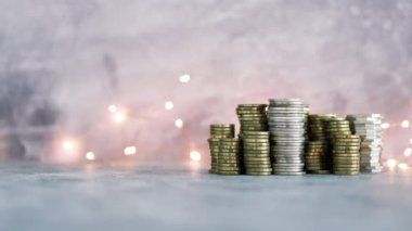 Peri ışığı, bolluk kavramı ve tasarruf hedeflerinize ulaşmak ile ışık arka planda büyük miktarda tasarruf çekimleri oluşturan farklı altın ve gümüş madeni paralar yığını