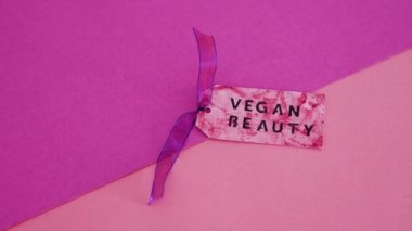 zulümsüz güzellik ürünleri konsepti, Geometrik pembe ve mor arkaplanda etiketli Vegan Güzellik mesajı kopya alanı ile