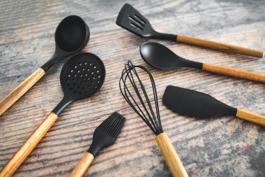 Eşleşen ahşap ve silikon mutfak aletleri, evde yemek pişirme ya da yemek pişirmeyi öğrenme kavramı.