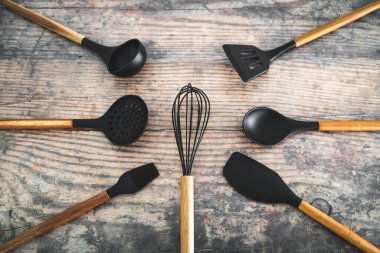 Eşleşen ahşap ve silikon mutfak aletleri, evde yemek pişirme ya da yemek pişirmeyi öğrenme kavramı.