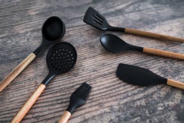 Eşleşen ahşap ve silikon mutfak aletleri, evde yemek pişirme ya da yemek pişirmeyi öğrenme kavramı.