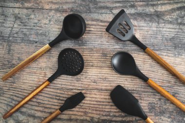 Eşleşen ahşap ve silikon mutfak aletleri, evde yemek pişirme ya da yemek pişirmeyi öğrenme kavramı.