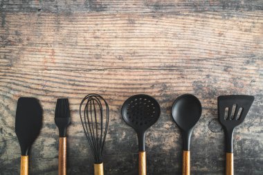 Eşleşen ahşap ve silikon mutfak aletleri, evde yemek pişirme ya da yemek pişirmeyi öğrenme kavramı.