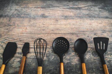 Eşleşen ahşap ve silikon mutfak aletleri, evde yemek pişirme ya da yemek pişirmeyi öğrenme kavramı.