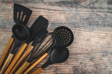 Eşleşen ahşap ve silikon mutfak aletleri, evde yemek pişirme ya da yemek pişirmeyi öğrenme kavramı.