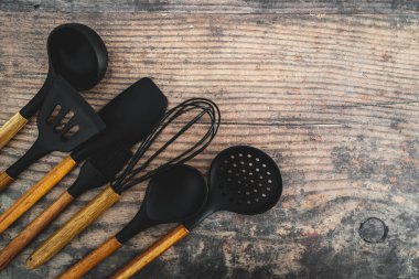 Eşleşen ahşap ve silikon mutfak aletleri, evde yemek pişirme ya da yemek pişirmeyi öğrenme kavramı.