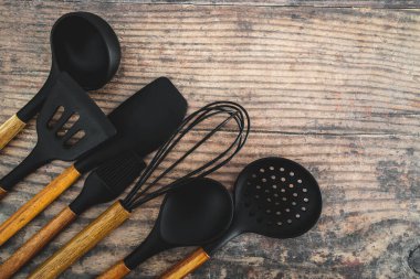 Eşleşen ahşap ve silikon mutfak aletleri, evde yemek pişirme ya da yemek pişirmeyi öğrenme kavramı.