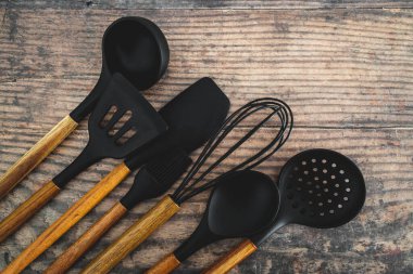 Eşleşen ahşap ve silikon mutfak aletleri, evde yemek pişirme ya da yemek pişirmeyi öğrenme kavramı.