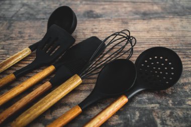 Eşleşen ahşap ve silikon mutfak aletleri, evde yemek pişirme ya da yemek pişirmeyi öğrenme kavramı.