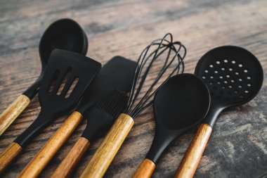 Eşleşen ahşap ve silikon mutfak aletleri, evde yemek pişirme ya da yemek pişirmeyi öğrenme kavramı.