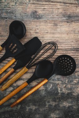 Eşleşen ahşap ve silikon mutfak aletleri, evde yemek pişirme ya da yemek pişirmeyi öğrenme kavramı.