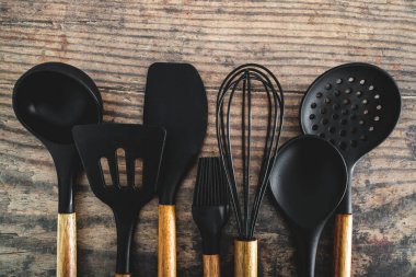 Eşleşen ahşap ve silikon mutfak aletleri, evde yemek pişirme ya da yemek pişirmeyi öğrenme kavramı.