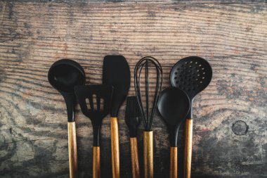 Eşleşen ahşap ve silikon mutfak aletleri, evde yemek pişirme ya da yemek pişirmeyi öğrenme kavramı.