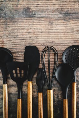 Eşleşen ahşap ve silikon mutfak aletleri, evde yemek pişirme ya da yemek pişirmeyi öğrenme kavramı.
