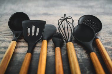 Eşleşen ahşap ve silikon mutfak aletleri, evde yemek pişirme ya da yemek pişirmeyi öğrenme kavramı.