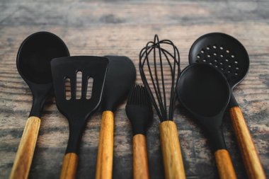 Eşleşen ahşap ve silikon mutfak aletleri, evde yemek pişirme ya da yemek pişirmeyi öğrenme kavramı.