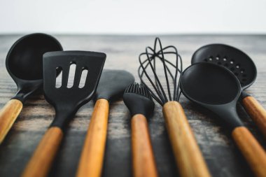 Eşleşen ahşap ve silikon mutfak aletleri, evde yemek pişirme ya da yemek pişirmeyi öğrenme kavramı.