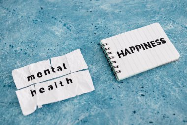 Not defterindeki mutluluk metni, yırtık yapışkan sayfa, psikoloji ve engelleri aşma konseptindeki ruh sağlığı metninin yanında.