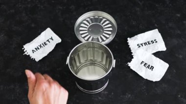 Stres, korku ve yanık kelimeler çöp kutusunun yanındaki yırtık sayfalarda, engelleri aşma konsepti ve zihinsel sağlık desteği