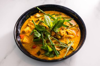 Çan biberli vejetaryen tofu körisi ve taze otlarla kaplı karışık sebzeler ve baharatlar, sağlıklı bitki temelli yemek tarifleri.