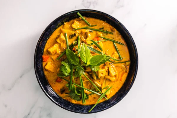 Çan biberli vejetaryen tofu körisi ve taze otlarla kaplı karışık sebzeler ve baharatlar, sağlıklı bitki temelli yemek tarifleri.