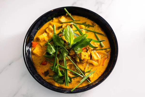 Çan biberli vejetaryen tofu körisi ve taze otlarla kaplı karışık sebzeler ve baharatlar, sağlıklı bitki temelli yemek tarifleri.