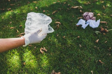 Parktaki yeşil çimlerden plastik torbalar ve ambalajlar almak, temizlik ve çevreye saygı kavramı