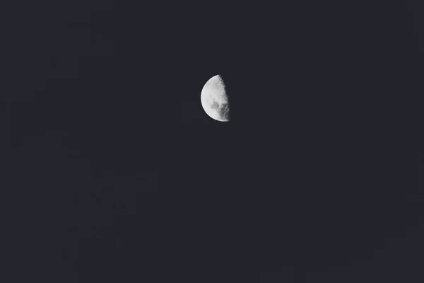 真っ黒の色調の望遠レンズで撮影された夜空の半月 — ストック写真