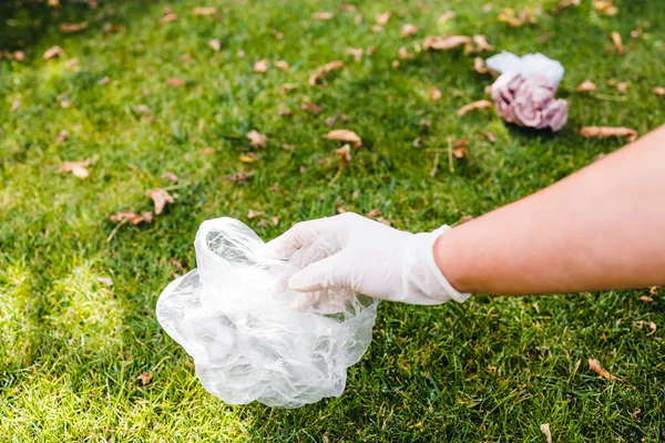 Parktaki yeşil çimlerden plastik torbalar ve ambalajlar almak, temizlik ve çevreye saygı kavramı
