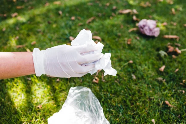 Parktaki yeşil çimlerden plastik torbalar ve ambalajlar almak, temizlik ve çevreye saygı kavramı