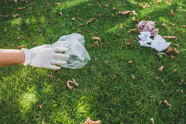 Parktaki yeşil çimlerden plastik torbalar ve ambalajlar almak, temizlik ve çevreye saygı kavramı