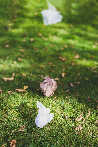 Plastik torbalar ve çöpler yeşil çimlerde terk edilmiş, çevreye saygı duyma ve tek kullanımlık plastikten kaçınma kavramı