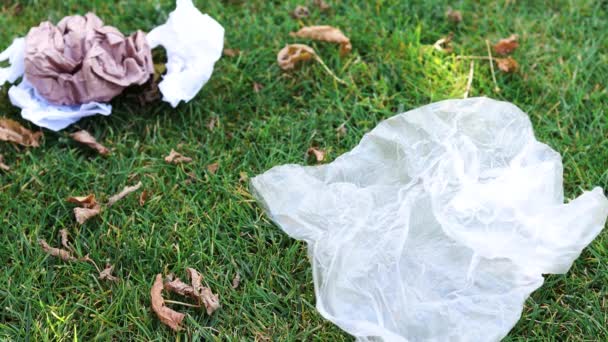 手从公园的绿色草坪上抓取塑料袋和包装纸 清洁和爱护环境的概念 — 图库视频影像