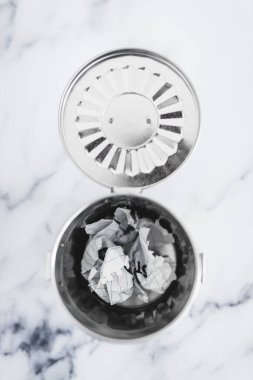 İçinde kağıt parçacıkları olan çöp tenekesi, yazar tıkanması ya da fikrinizi değiştirme kavramı.